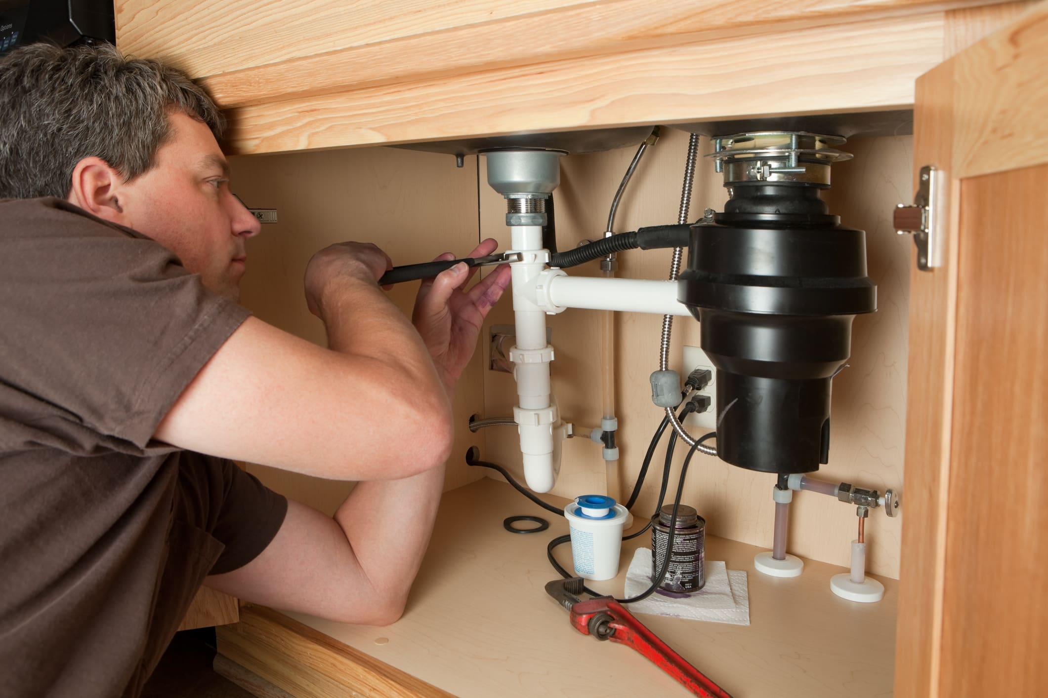 Technician working on garbage disposal system
